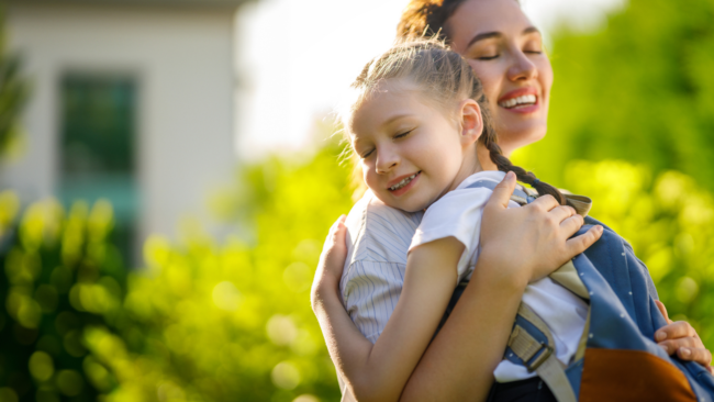 Parent hugging child emotionally first day of school